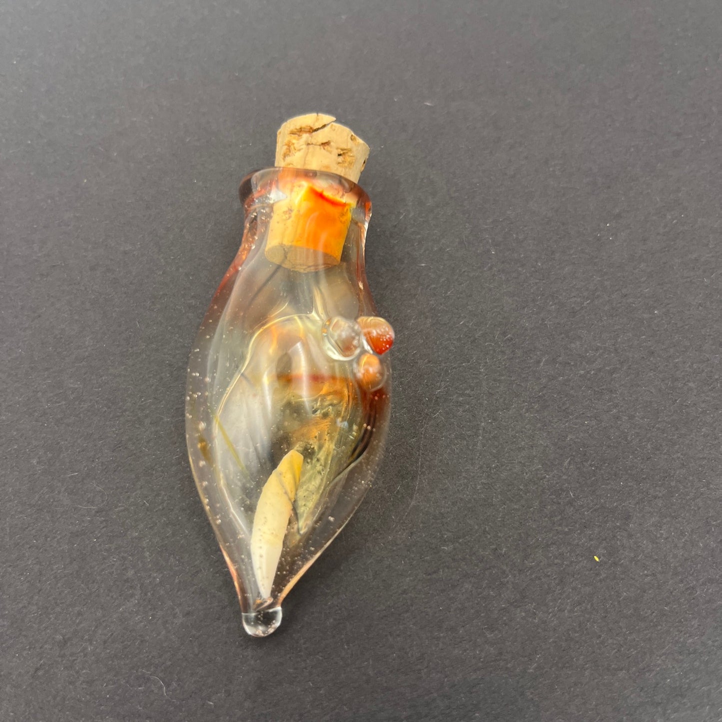 Vulture vial with raccoon tooth